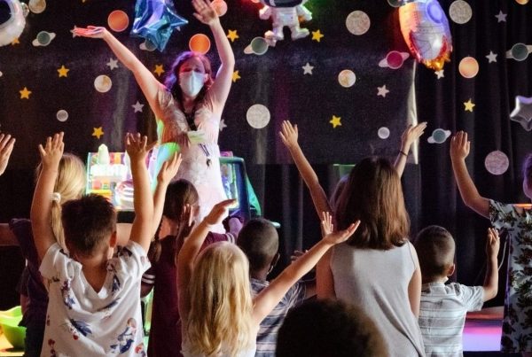 Children enjoy a lively puppet show with colorful characters and bright lights.